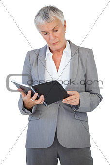 Concentrated businesswoman reading notepad