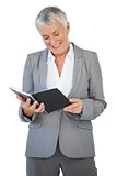Smiling businesswoman reading notepad