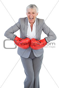 Happy businesswoman wearing boxing gloves