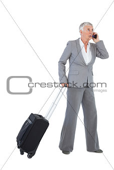 Businesswoman with her luggage and calling someone