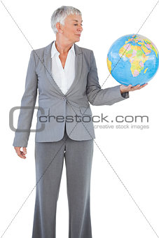 Businesswoman holding and looking at globe
