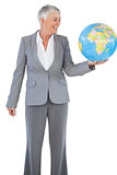 Smiling businesswoman holding and looking at globe