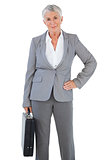 Businesswoman holding briefcase and putting her hand on hip