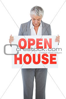 Estate agent holding and looking at sign for open house