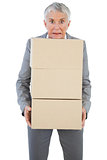 Businesswoman holding heavy cardboard boxes