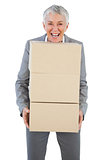 Smiling businesswoman holding heavy cardboard boxes