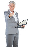 Businesswoman with diary pointing her finger at camera