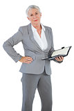 Businesswoman holding diary with her hand on hip
