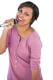 Smiling brunette singing with her microphone