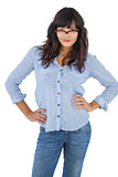 Young woman with her hands on hips and wearing glasses
