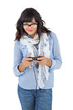 Young woman wearing scarf and glasses playing video games