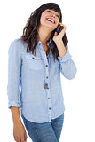 Smiling brunette with her mobile phone calling someone