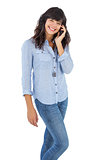 Cheerful brunette with her mobile phone calling someone