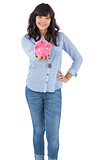 Young woman showing her piggy bank