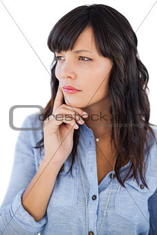 Thinking brunette with finger on her face looking away