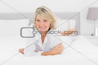 Cheerful woman lying on her bed
