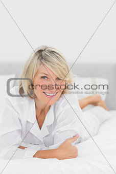 Happy woman lying on her bed