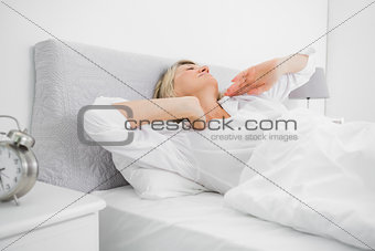 Blonde woman stretching and waking up