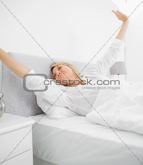 Blonde woman waking up and stetching