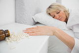 Woman lying motionless beside pills
