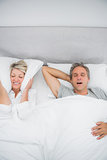 Woman blocking her ears because of partners snoring