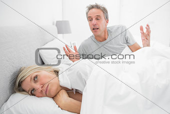 Man arguing with his partner in bed
