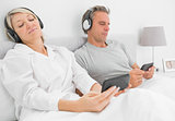 Couple listening to music on their smartphones