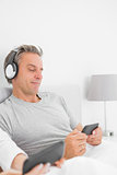 Smiling man listening to music on his smartphone