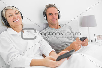 Smiling couple to music on their smartphones