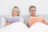 Relaxed couple reading in bed