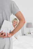 Man hiding present behind his back for happy partner