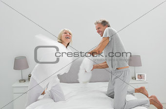 Fun couple having a pillow fight