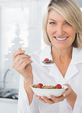 Smiling woman having cereal for breakfast