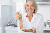 Cheerful blonde eating cereal for breakfast