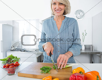 Happy woman chopping vegetables