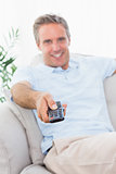 Cheerful man on his couch watching tv