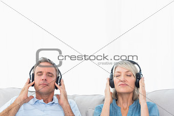 Couple relaxing and listening to music on the sofa