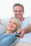 Cheerful couple relaxing at home watching tv