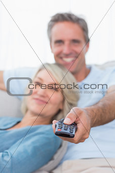 Cheerful couple relaxing at home watching tv