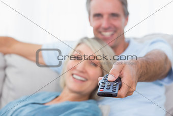 Happy couple relaxing at home watching tv