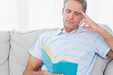 Man relaxing on his couch with a book