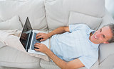 Man typing on laptop at home