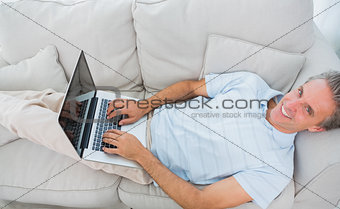 Man typing on laptop at home