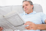 Man reading the news on couch