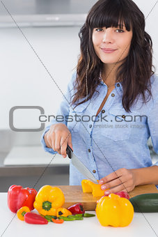 Pretty brunette slicing vegetables