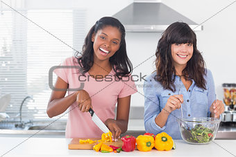 Happy friends preparing a salad together