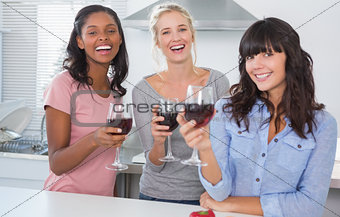 Cheerful friends enjoying glasses of red wine