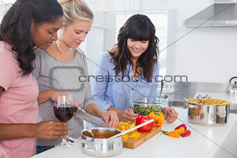 Smiling friends preparing a meal together