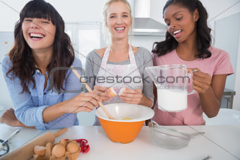Laughing friends making pastry together