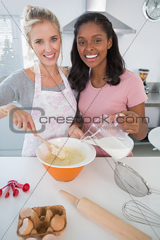 Pretty friends making pastry together looking at camera